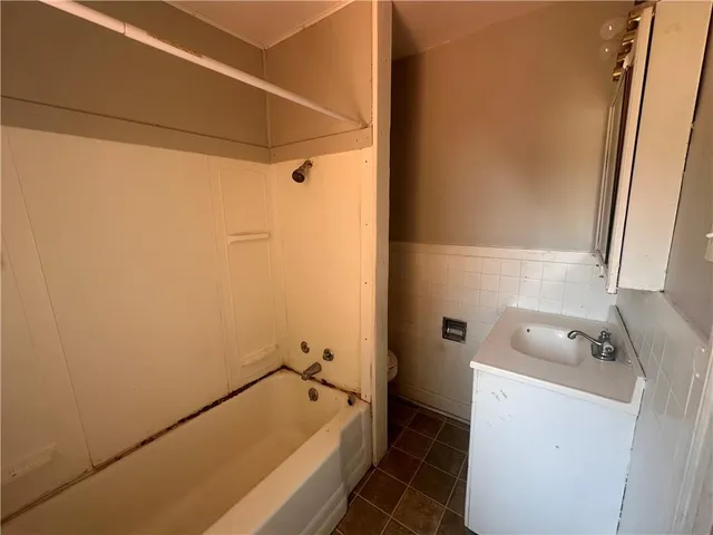 a bathroom with a tub sink and toilet