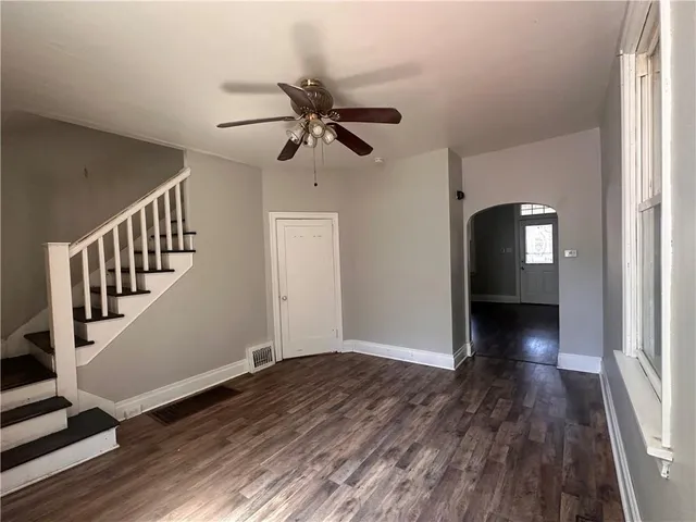 a view of a hallway with wooden floor and staircase