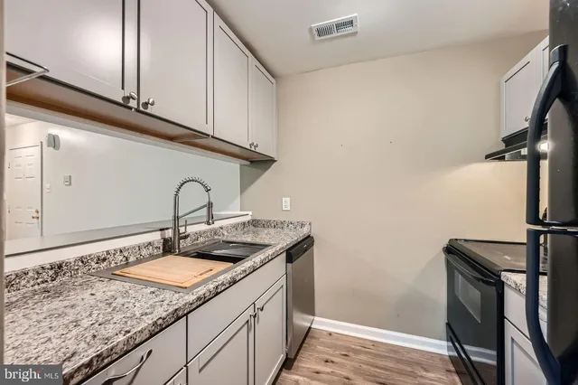 a view of an empty room with chandelier fan and fire place