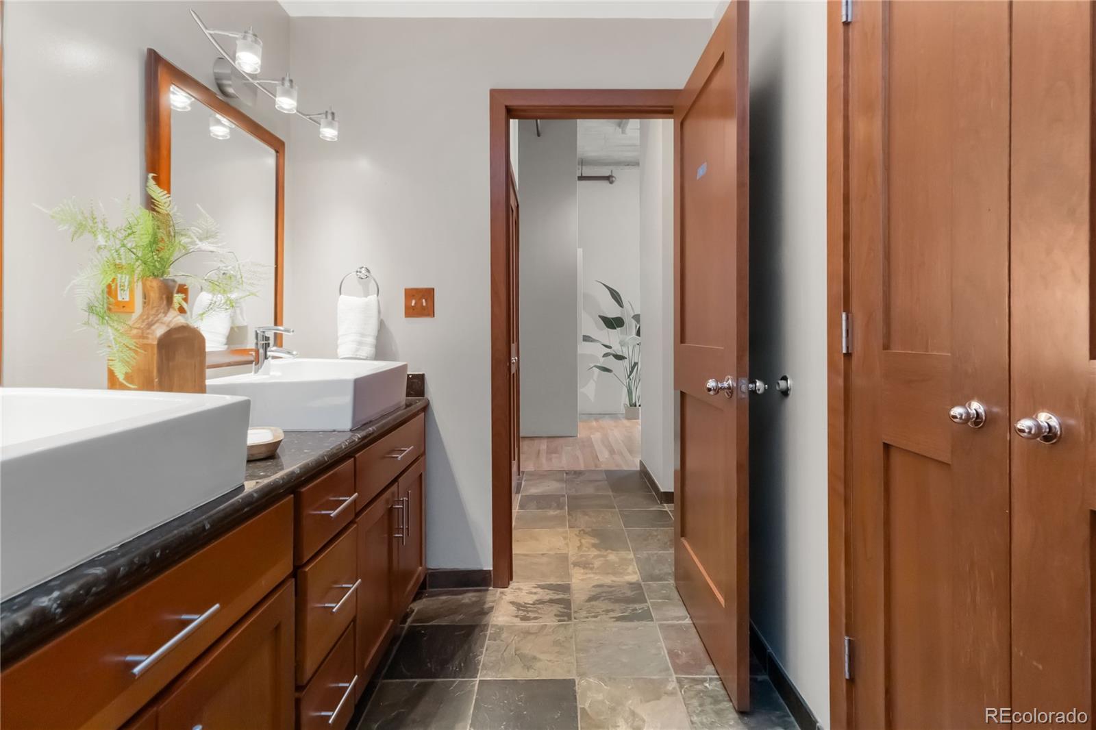 1863 Wazee Street, Unit 6E Denver, CO 80202 - Photo 39 of 49 a bathroom with a double vanity sink a mirror and a shower