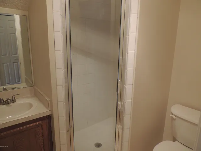 a bathroom with a sink and mirror with toilet