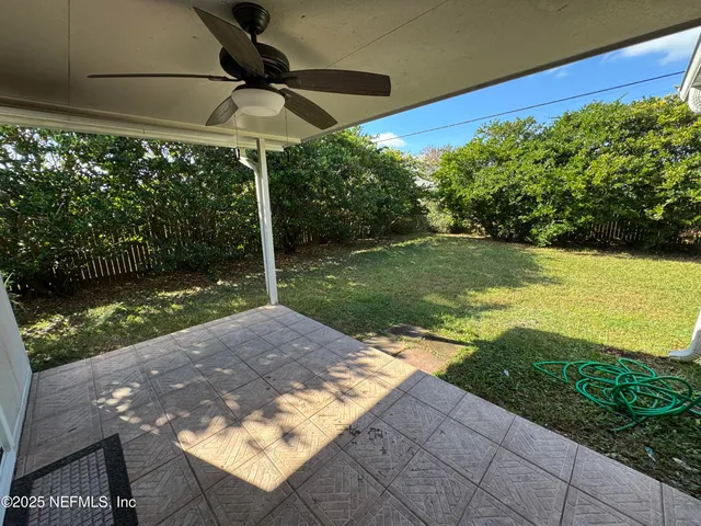 a view of a backyard with table and chairs under an umbrella