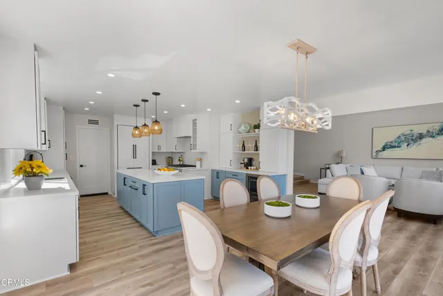 a view of a dining room and livingroom with furniture wooden floor a chandelier