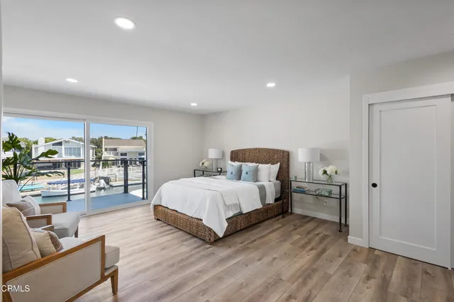 a spacious bedroom with a bed and wooden floor