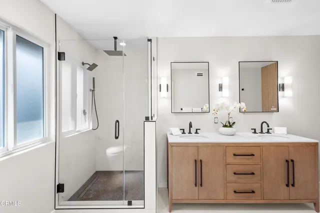 a bathroom with a double vanity sink mirror and bathtub