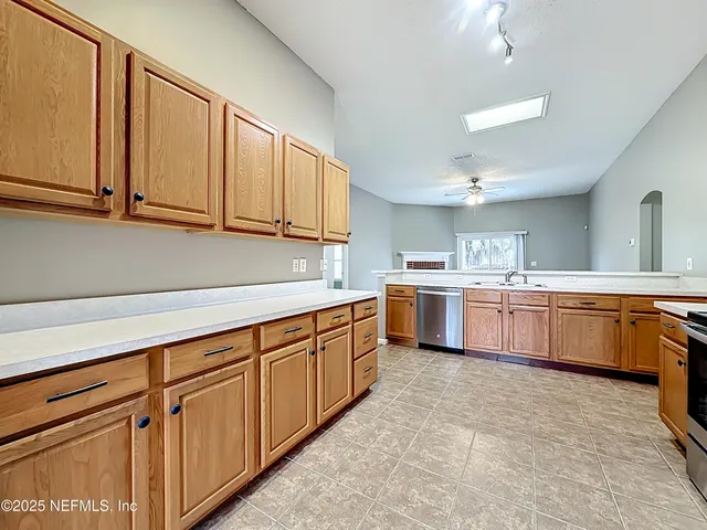 a kitchen with stainless steel appliances granite countertop a sink counter space cabinets and a large window