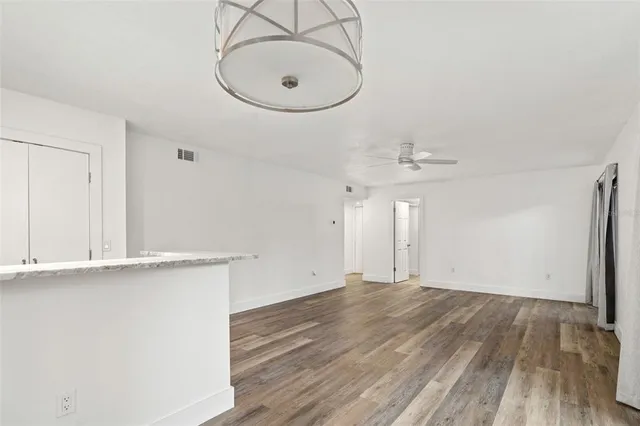an empty room with wooden floor and mirror