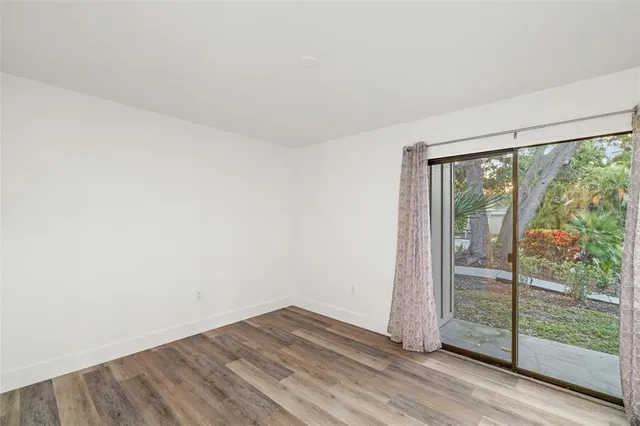 an empty room with wooden floor and sliding door