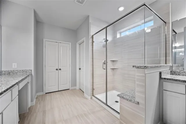 a bathroom with a granite countertop shower a sink and toilet