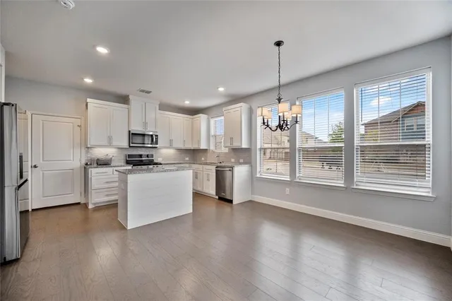 a kitchen with kitchen island white cabinets and white appliances