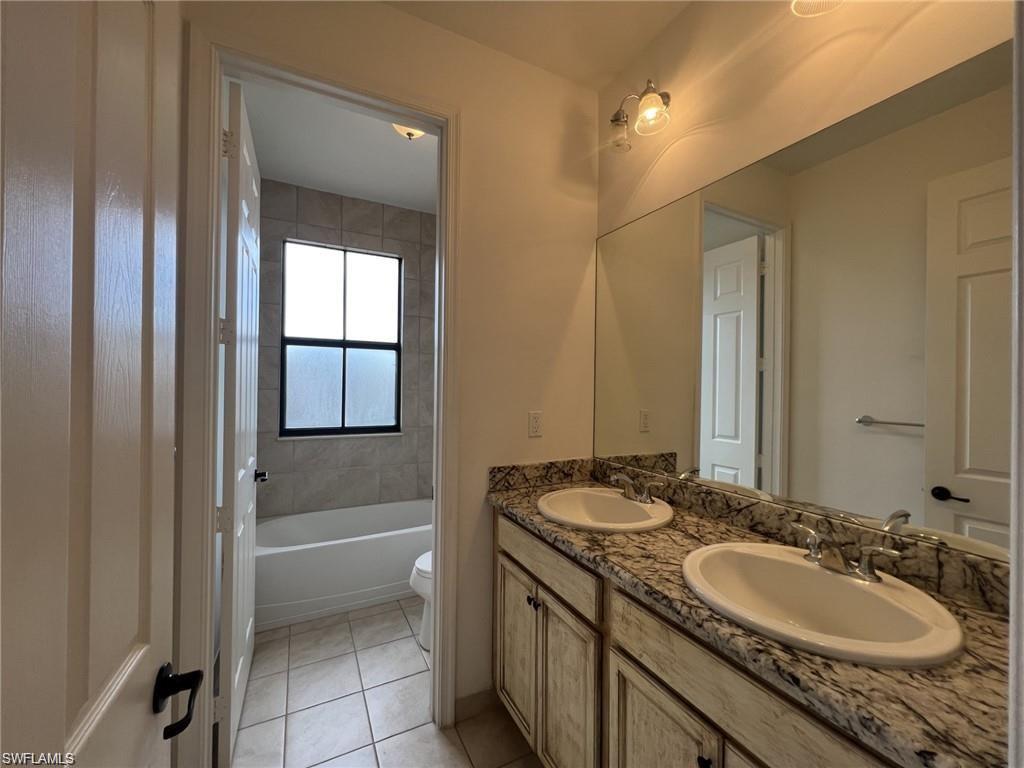 5459 Useppa Drive Ave Maria, FL 34142 - Photo 11 of 27 a bathroom with a granite countertop sink and a mirror