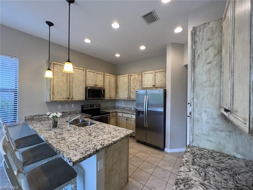 5459 Useppa Drive Ave Maria, FL 34142 - Photo 2 of 27 a kitchen with stainless steel appliances kitchen island granite countertop a refrigerator and a sink
