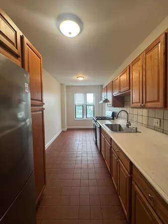 a large kitchen with a large window and stainless steel appliances