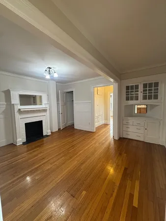 a view of empty room with wooden floor and fireplace