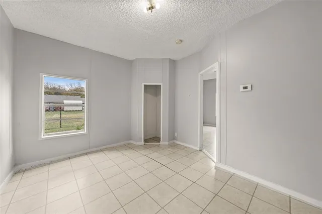 a view of an empty room with window and closet area