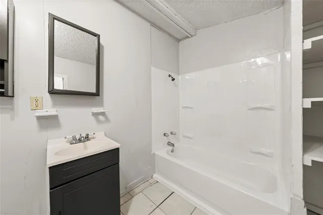 a bathroom with a bathtub shower sink and vanity