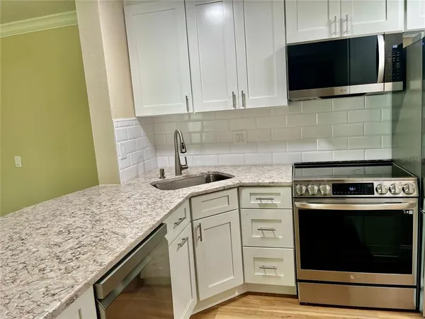 a kitchen with stainless steel appliances granite countertop a sink and a microwave