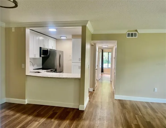 a view of a kitchen with wooden floor and a window