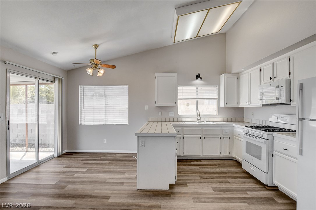 6209 Warm River Road Las Vegas, NV 89108 - Photo 16 of 39 A well-lit kitchen with sleek appliances and direct access to an outdoor area, perfect for daily living.