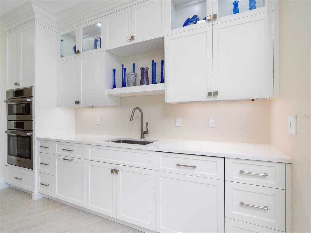 790 North Manasota Key Road Englewood, FL 34223 - Photo 33 of 80 a kitchen with white cabinets and white appliances