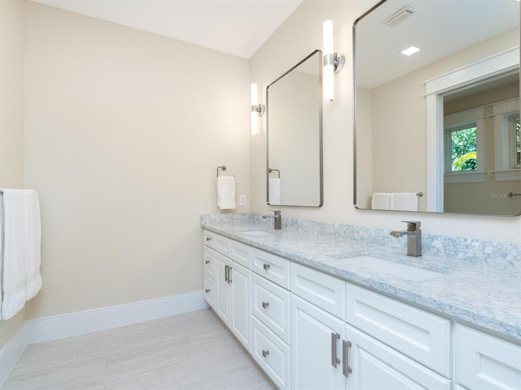 790 North Manasota Key Road Englewood, FL 34223 - Photo 37 of 80 a bathroom with a granite countertop sink and a mirror