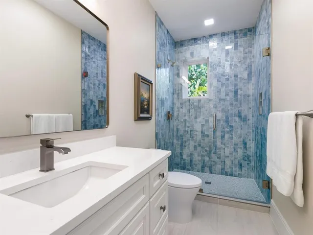 a view of a road with plants and large trees