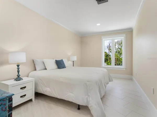 a spacious bedroom with a bed and large window