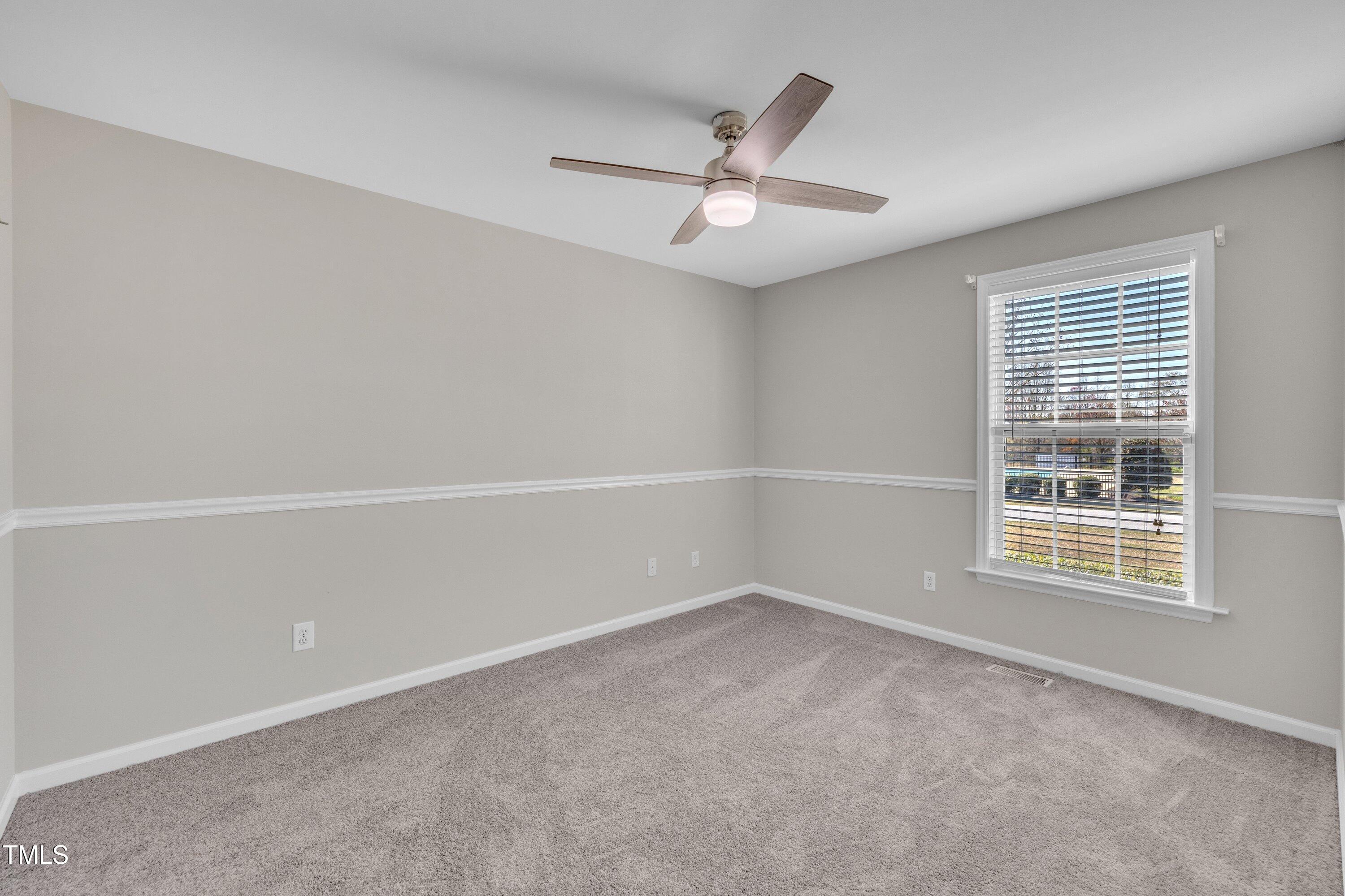 147 Tralee Drive Smithfield, NC 27577 - Photo 17 of 43 an empty room with a window and ceiling fan