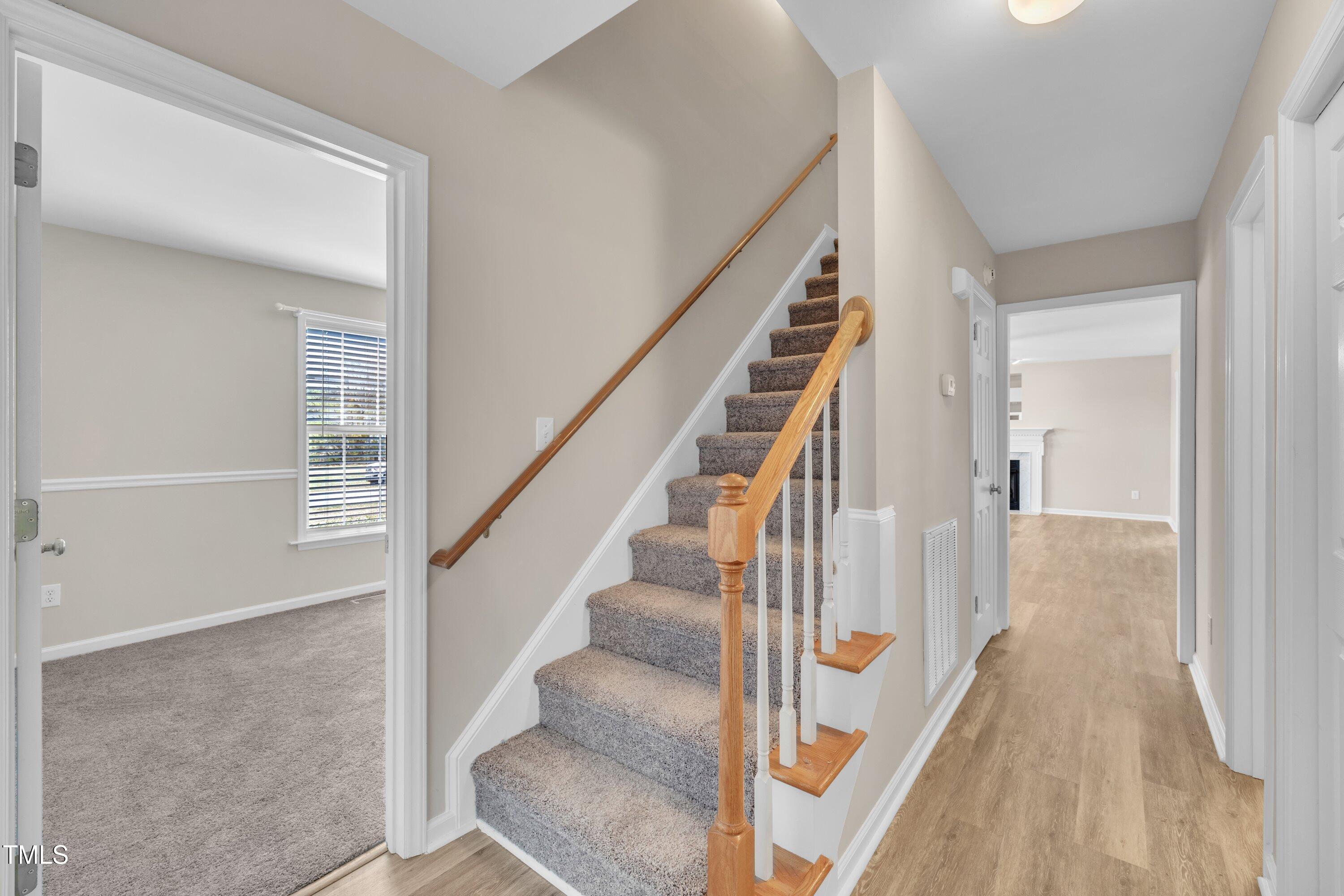 147 Tralee Drive Smithfield, NC 27577 - Photo 20 of 43 a view of staircase with lots of frames on wall and wooden floor