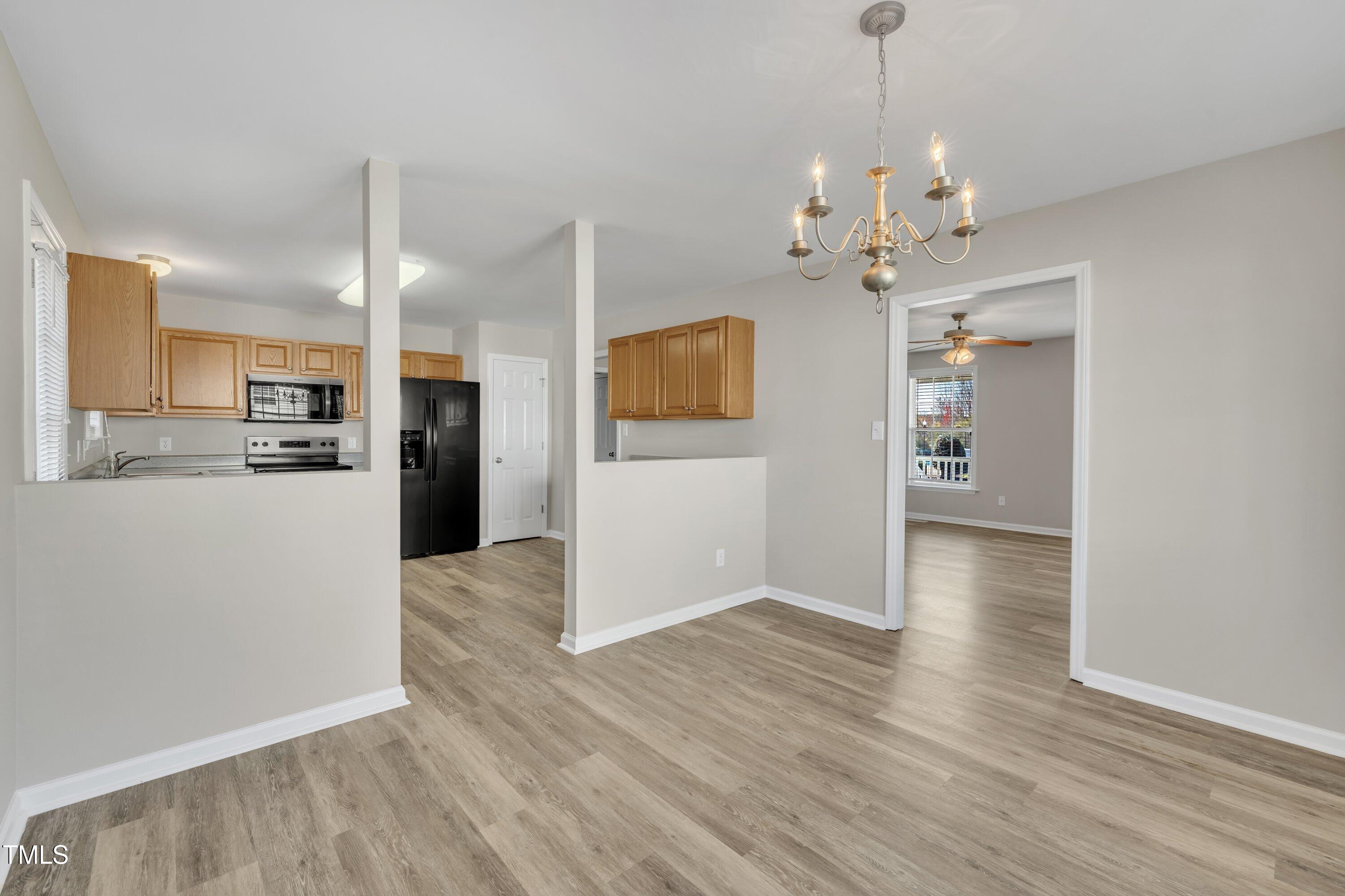 147 Tralee Drive Smithfield, NC 27577 - Photo 33 of 43 a view of a kitchen with a refrigerator a ceiling fan and wooden floor