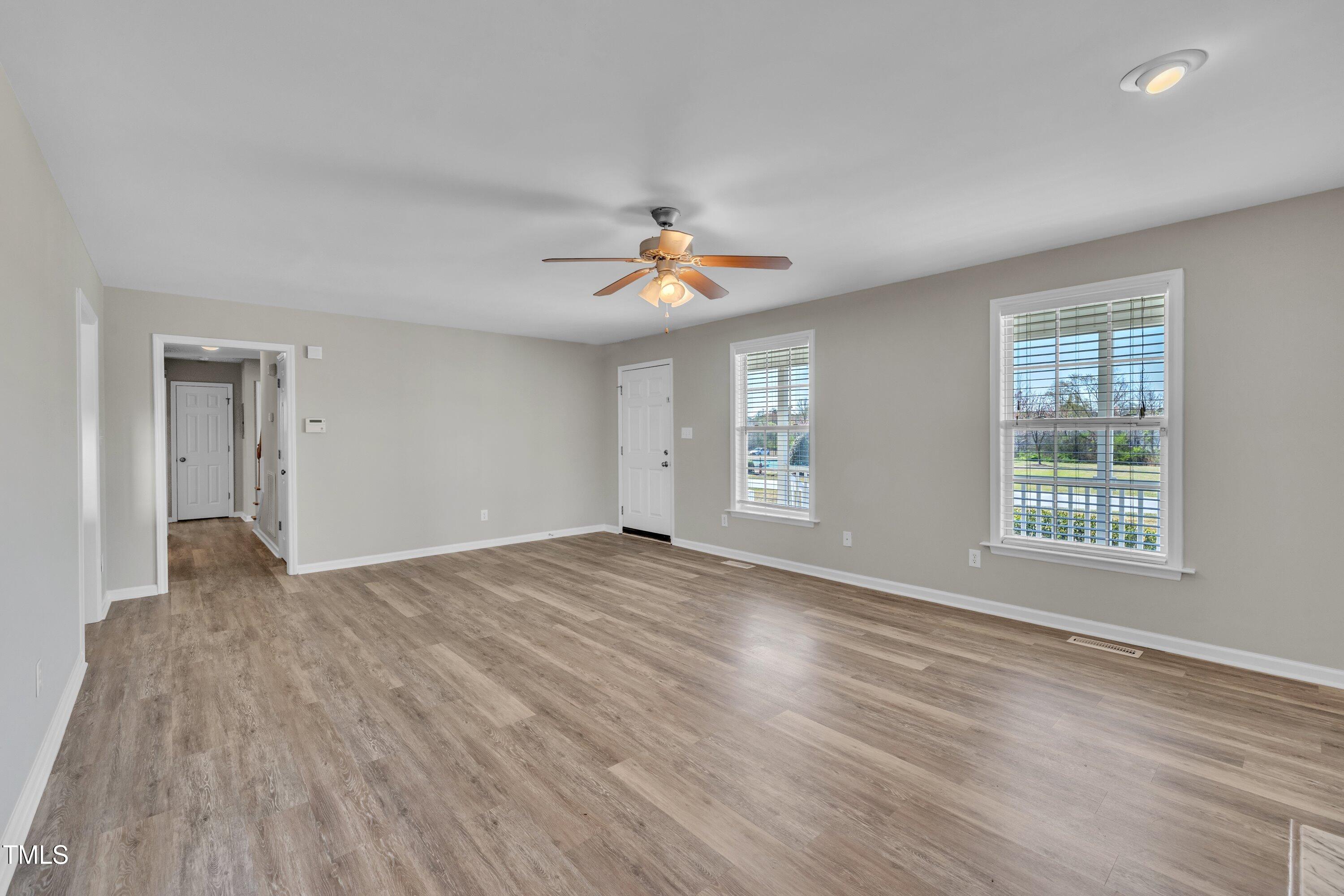 147 Tralee Drive Smithfield, NC 27577 - Photo 8 of 43 a view of an empty room with a window and wooden floor