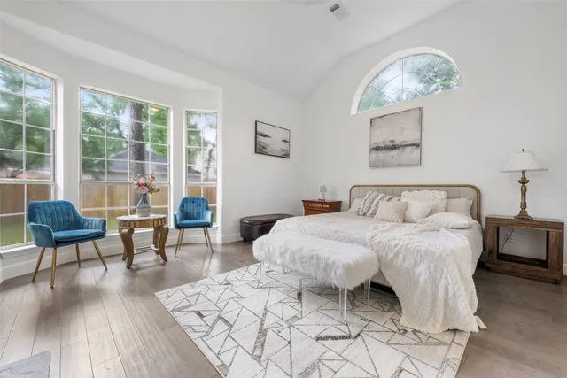 a spacious bedroom with a bed a table and chair