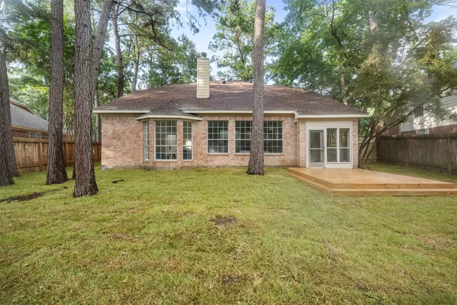 an aerial view of residential house with outdoor space and trees all around