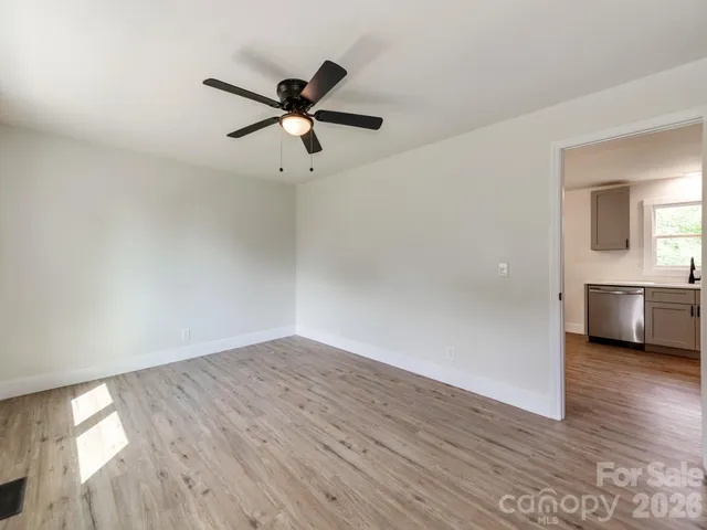 a view of a room with wooden floor and a ceiling fan