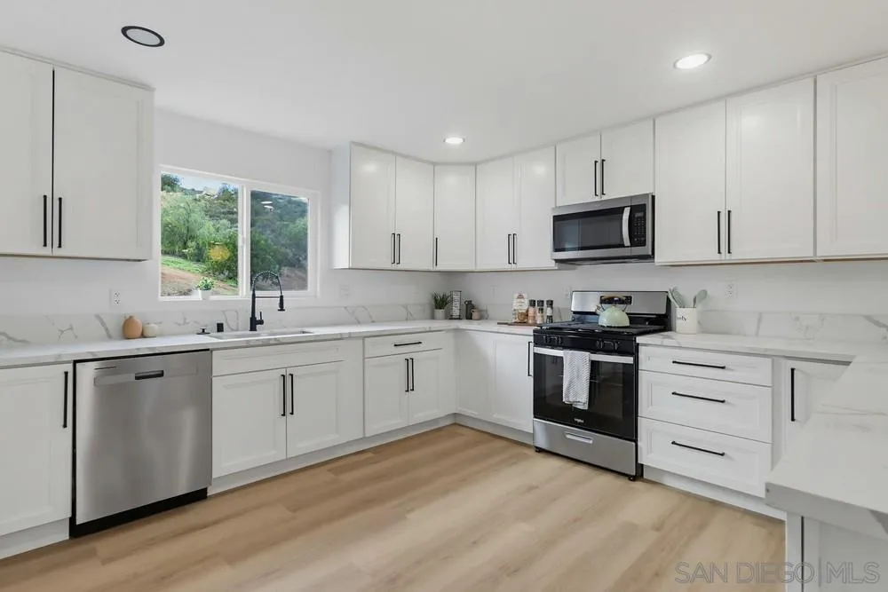 15751 Lyons Valley Road Jamul, CA 91935 - Photo 11 of 59 a kitchen with granite countertop white cabinets a window and a sink