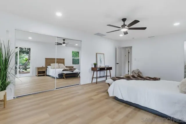 a spacious bedroom with a bed and a chandelier