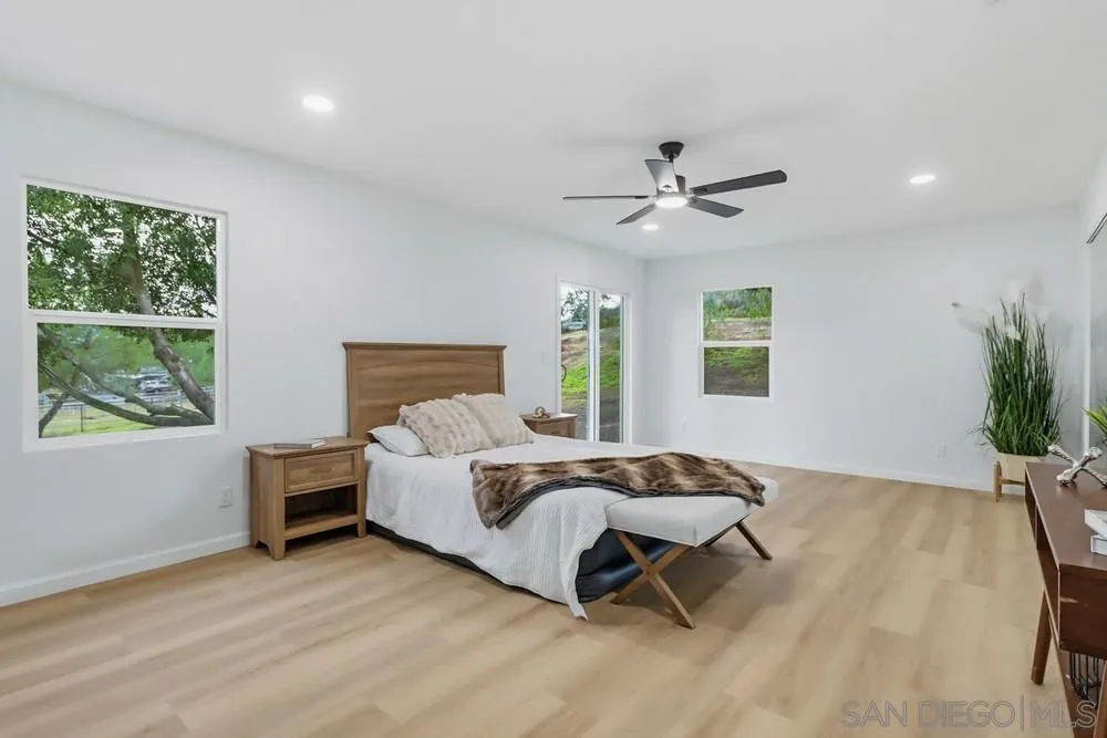 15751 Lyons Valley Road Jamul, CA 91935 - Photo 23 of 59 a spacious bedroom with a bed and a chandelier