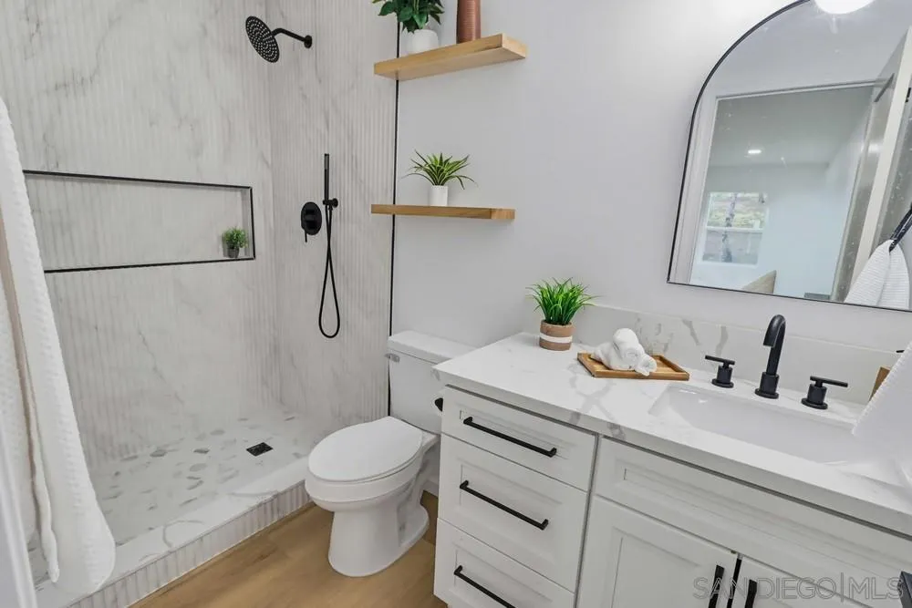 15751 Lyons Valley Road Jamul, CA 91935 - Photo 25 of 59 a bathroom with a granite countertop sink a toilet and a shower