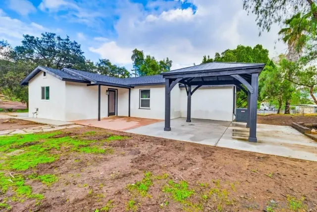 a view of a house with backyard and tree