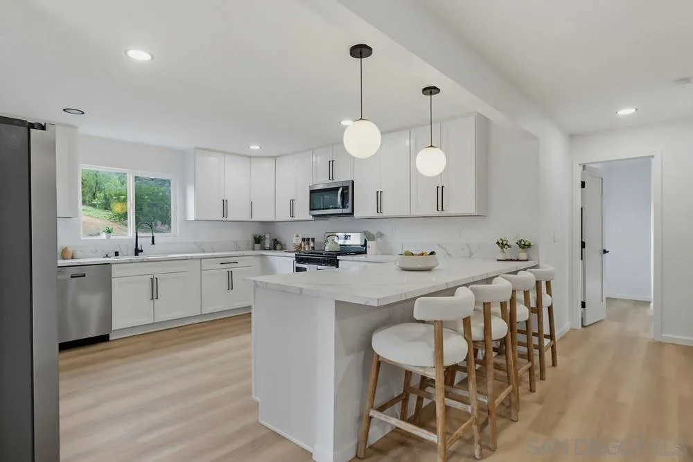 15751 Lyons Valley Road Jamul, CA 91935 - Photo 8 of 59 a kitchen with white cabinets stainless steel appliances and kitchen island
