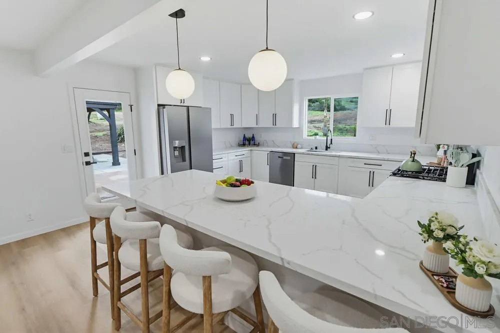 15751 Lyons Valley Road Jamul, CA 91935 - Photo 9 of 59 a kitchen with a dining table cabinets and stainless steel appliances