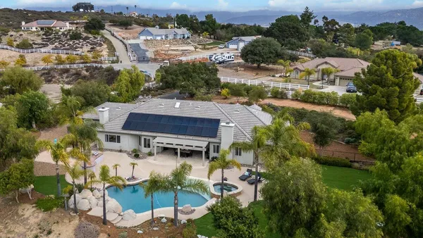 an aerial view of residential houses with outdoor space and parking