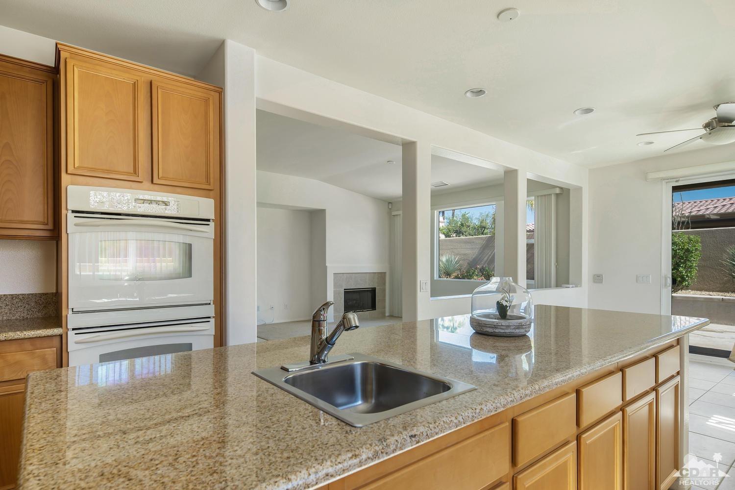 36 Shoreline Drive Rancho Mirage, CA 92270 - Photo 16 of 38 a kitchen with granite countertop a sink and refrigerator