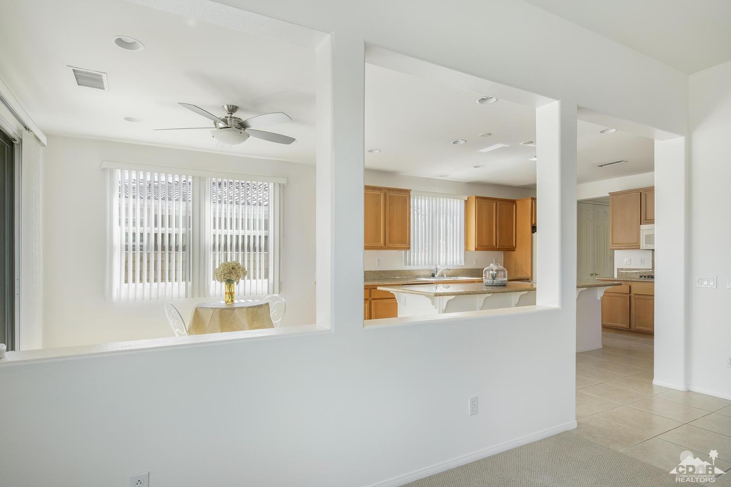 36 Shoreline Drive Rancho Mirage, CA 92270 - Photo 10 of 38 a large white kitchen with kitchen island a large window a sink and stainless steel appliances