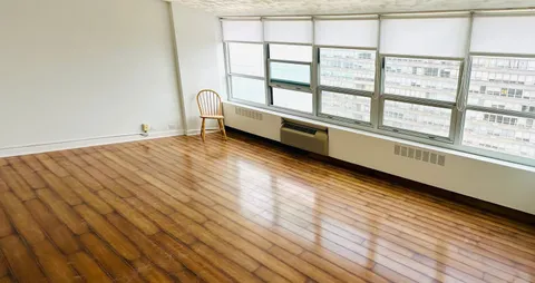 view of an empty room with wooden floor and a window