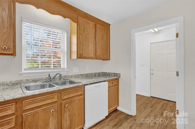 a kitchen with granite countertop cabinets sink and window