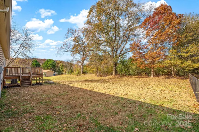 a view of a yard with wooden fence