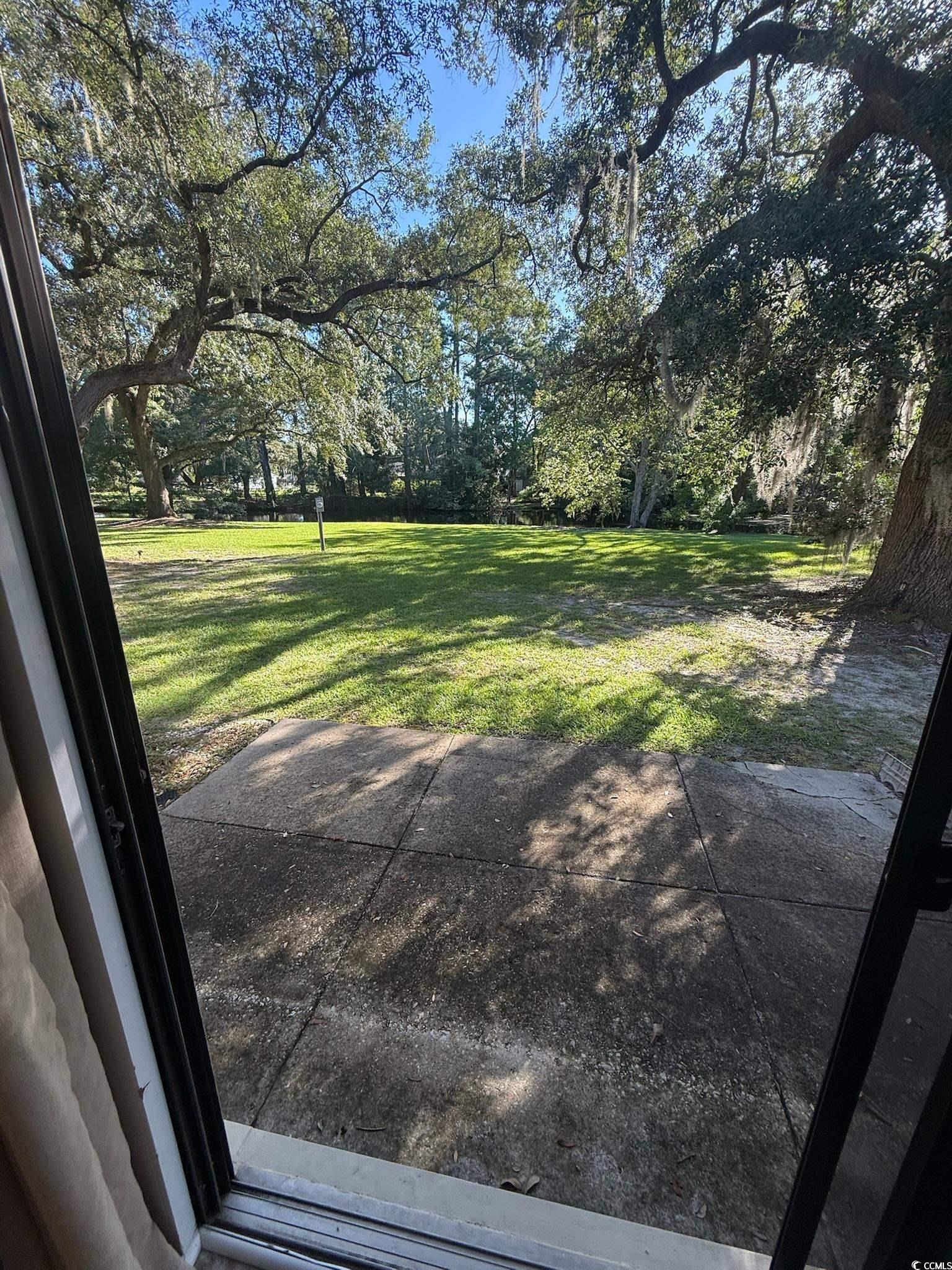 80 Wedgefield Village Road, Unit 46 Georgetown, SC 29440 - Photo 17 of 19 View of grassy yard with view of scattered trees