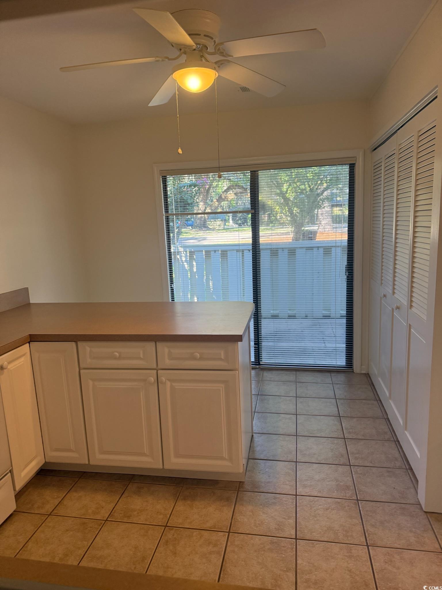 80 Wedgefield Village Road, Unit 46 Georgetown, SC 29440 - Photo 5 of 19 Kitchen with white cabinets, light tile patterned flooring, ceiling fan, and a peninsula