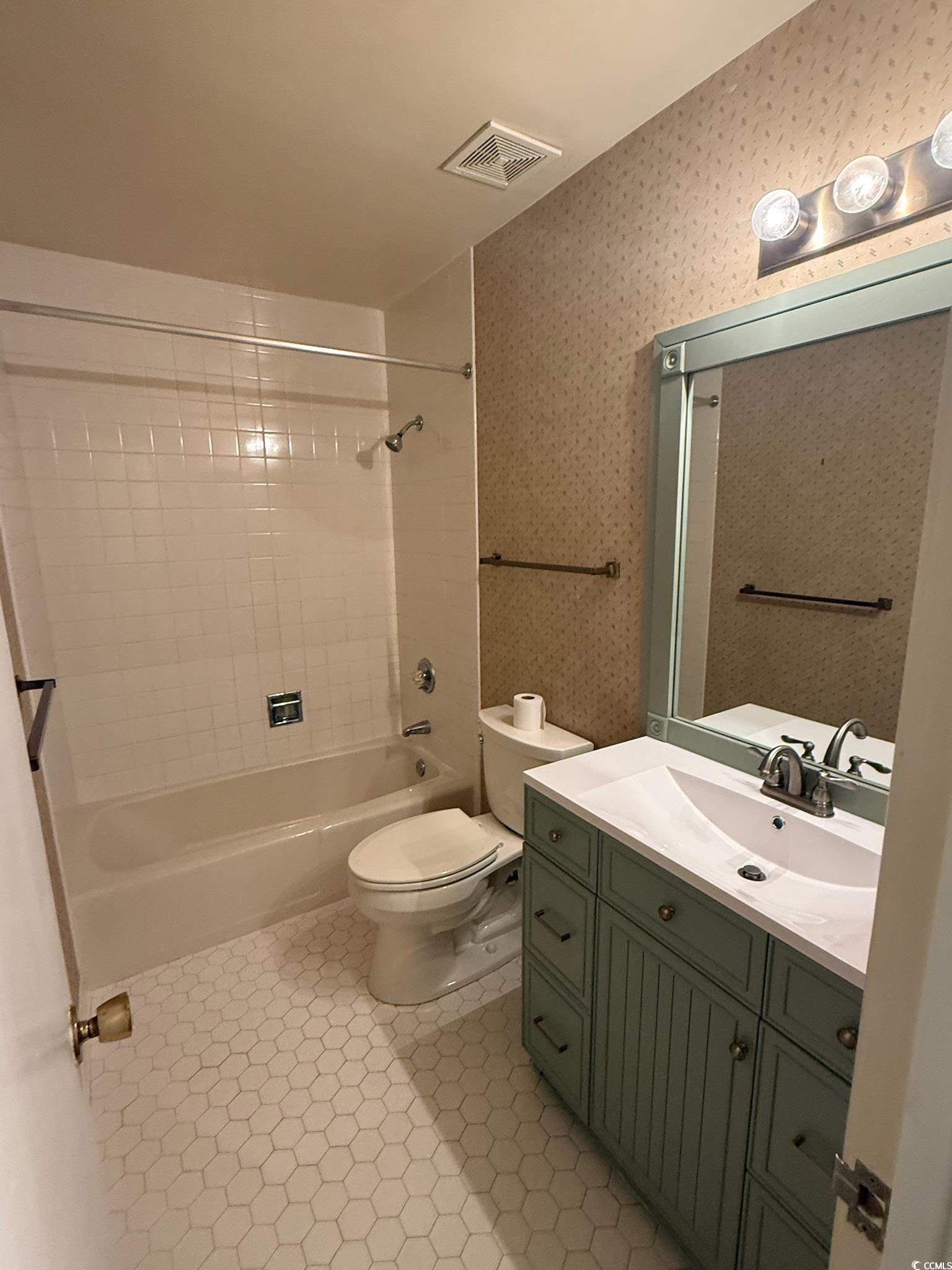 80 Wedgefield Village Road, Unit 46 Georgetown, SC 29440 - Photo 9 of 19 Full bathroom featuring washtub / shower combination, vanity, light tile patterned floors, and wallpapered walls